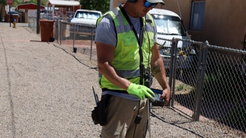 Field technician using handheld device for water system inspection