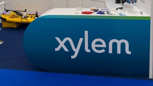 Xylem trade show stand with curved blue signage and a yellow Surfbee water drone displayed on the show floor
